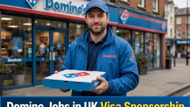 Domino Jobs in UK with Visa Sponsorship delivery driver holding pizza box in front of Domino's store